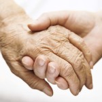 adult helping senior in hospital