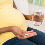 Pregnant Woman Taking Medicine At Home