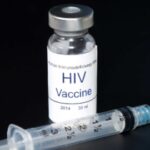 Hypothetical AIDS/HIV vaccine with syringe on black.