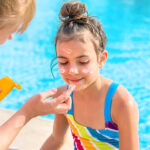 Mother Applying Suntan Lotion On Daughters Face