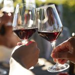 Friends toasting glasses with red wine in wedding